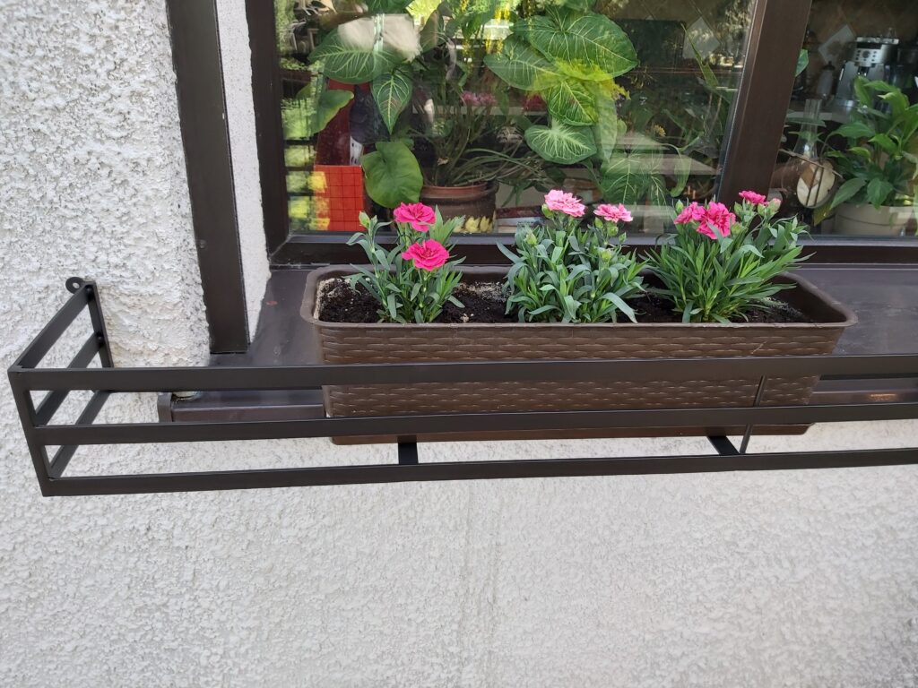 Solidna metalowa barierka i elegancki kwietnik na parapet zewnętrzny.