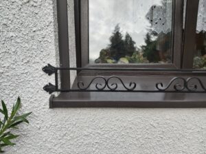 Dekoracyjny kwietnik na zewnątrz okna, idealny do ogrodów miejskich.