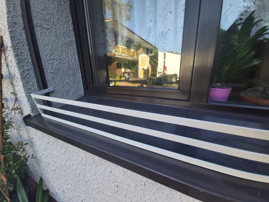 Prosty, elegancki kwietnik na parapet, idealny do ozdobienia zewnętrznej elewacji domu.