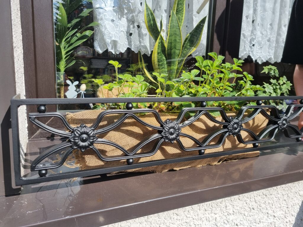 Solidna metalowa barierka z bogatymi zdobieniami - unikalny element dekoracyjny dla Twojego parapetu.