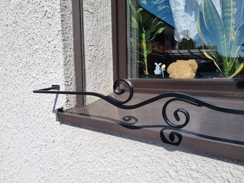 Solidna metalowa barierka z minimalistycznym kwietnikiem na parapet - harmonijne i funkcjonalne.