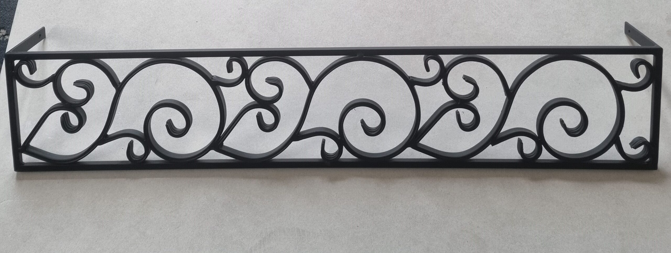 Solidny metalowy płotek z ozdobnym kwietnikiem na parapet - styl i funkcjonalność.