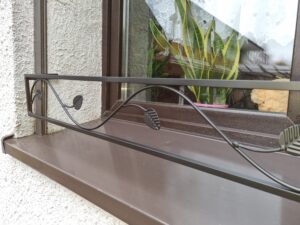 Solidna metalowa barierka z delikatnym wzorem gałęzi drzewa - eleganckie rozwiązanie dla Twojej elewacji.