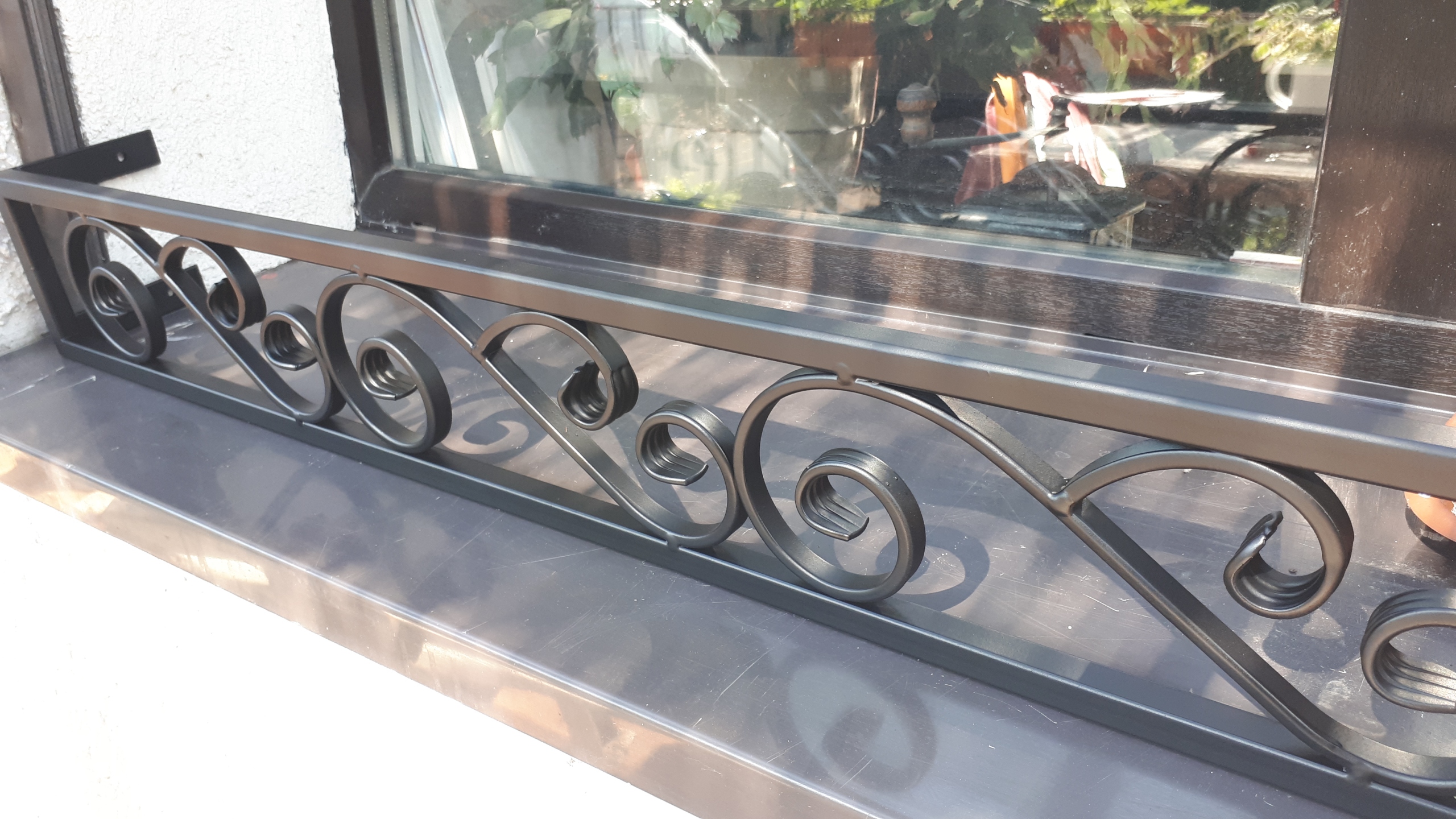 Solidna metalowa barierka i elegancki kwietnik na parapet - harmonia i funkcjonalność.