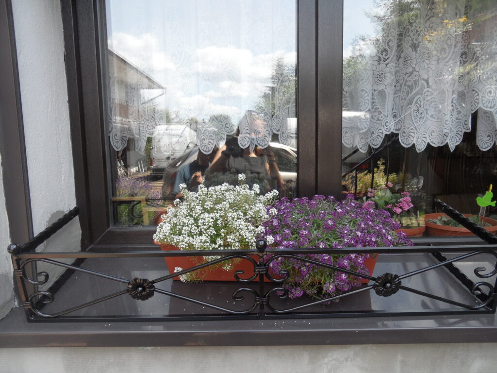 Elegancki metalowy kwietnik-na parapet do skrzynki z kwiatami, ręcznie gięty.