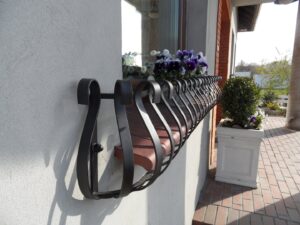 Solidna metalowa barierka i elegancki kwietnik na parapet zewnętrzny.