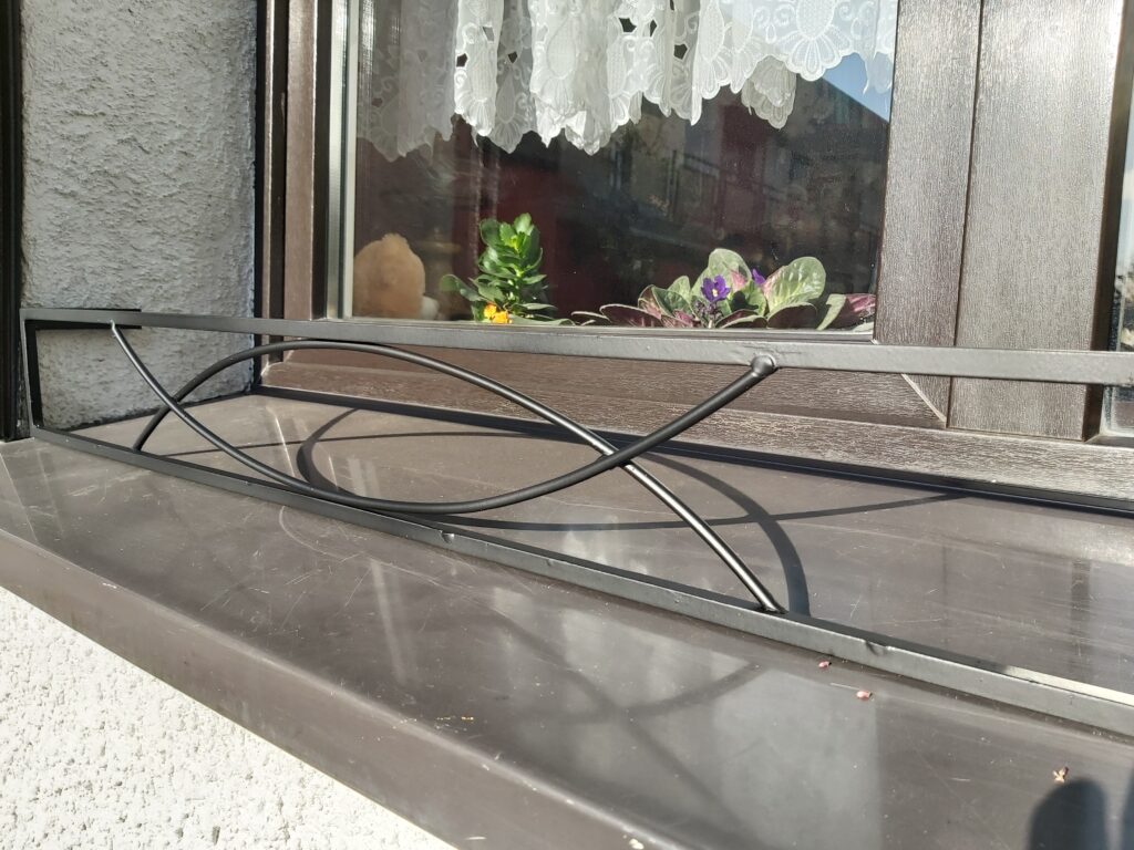 Elegancki metalowy kwietnik-na parapet do skrzynki z kwiatami.