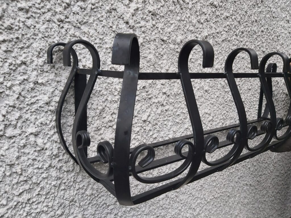 Estetyczny kwietnik na zewnątrz parapetu - funkcjonalna dekoracja ogrodowa.