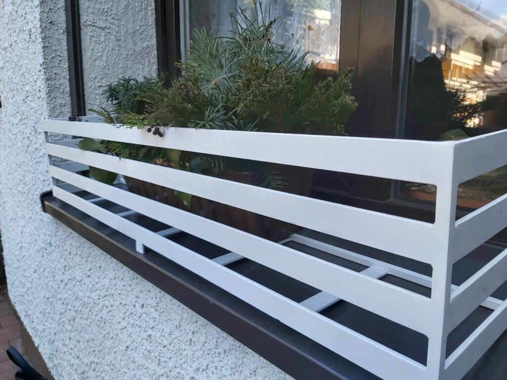 Nowoczesny kwietnik na zewnątrz parapetu - funkcjonalna ozdoba dla roślin.